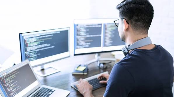 Monitors with code on the screen and a developer